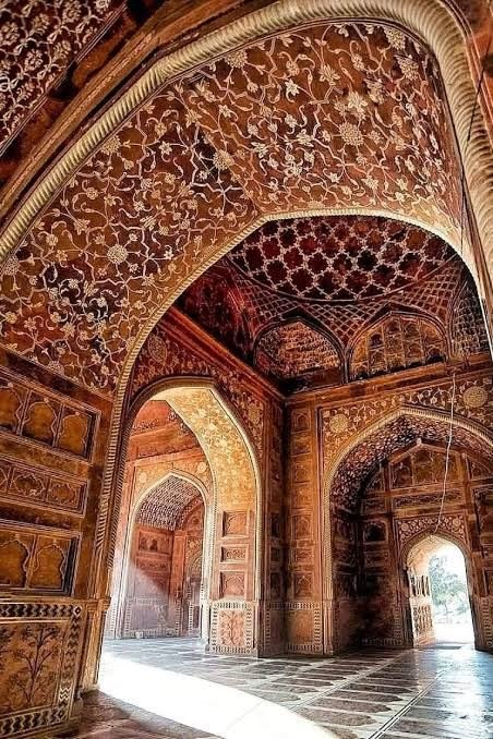 Red sandstone arches with painted floral decoration inside the mosque on the Taj Mahal grounds